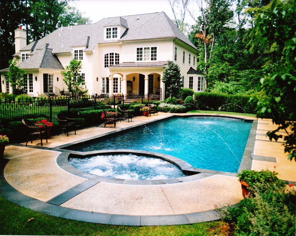 Large elegant backyard concrete and custom-shaped hot tub photo in Philadelphia