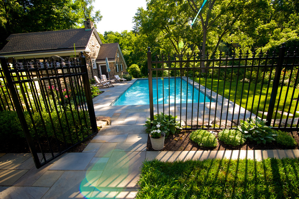 Idéer för att renovera en mellanstor vintage rektangulär pool längs med huset, med naturstensplattor
