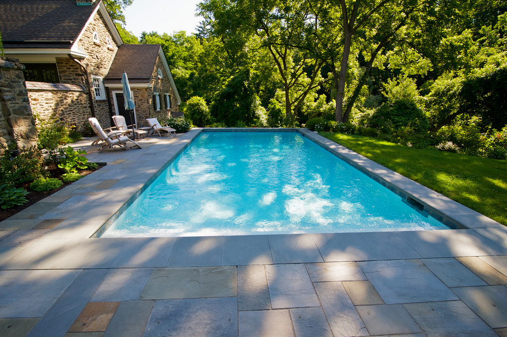 Idee per una piscina chic rettangolare di medie dimensioni e nel cortile laterale con pavimentazioni in pietra naturale