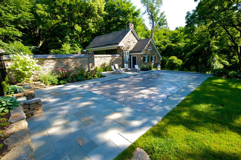Diseño de piscina clásica de tamaño medio rectangular en patio lateral con adoquines de piedra natural