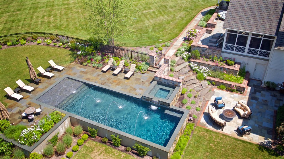 Ispirazione per una piscina monocorsia chic rettangolare di medie dimensioni e dietro casa con fontane e pavimentazioni in pietra naturale