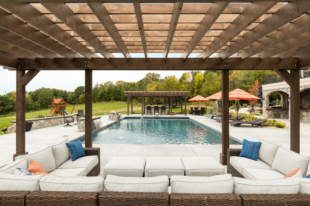 Foto de piscinas y jacuzzis clásicos grandes rectangulares en patio trasero con suelo de hormigón estampado