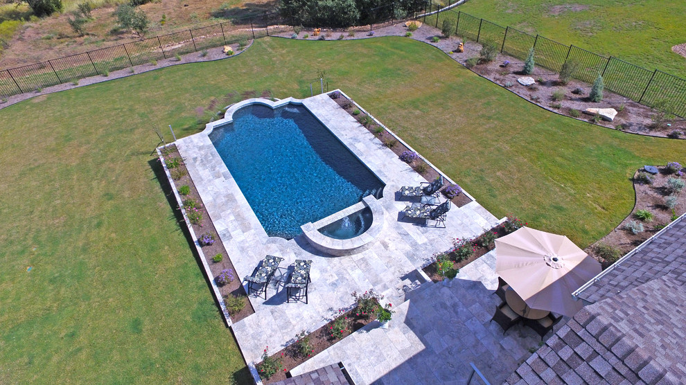 Diseño de piscinas y jacuzzis clásicos grandes rectangulares en patio trasero con adoquines de piedra natural