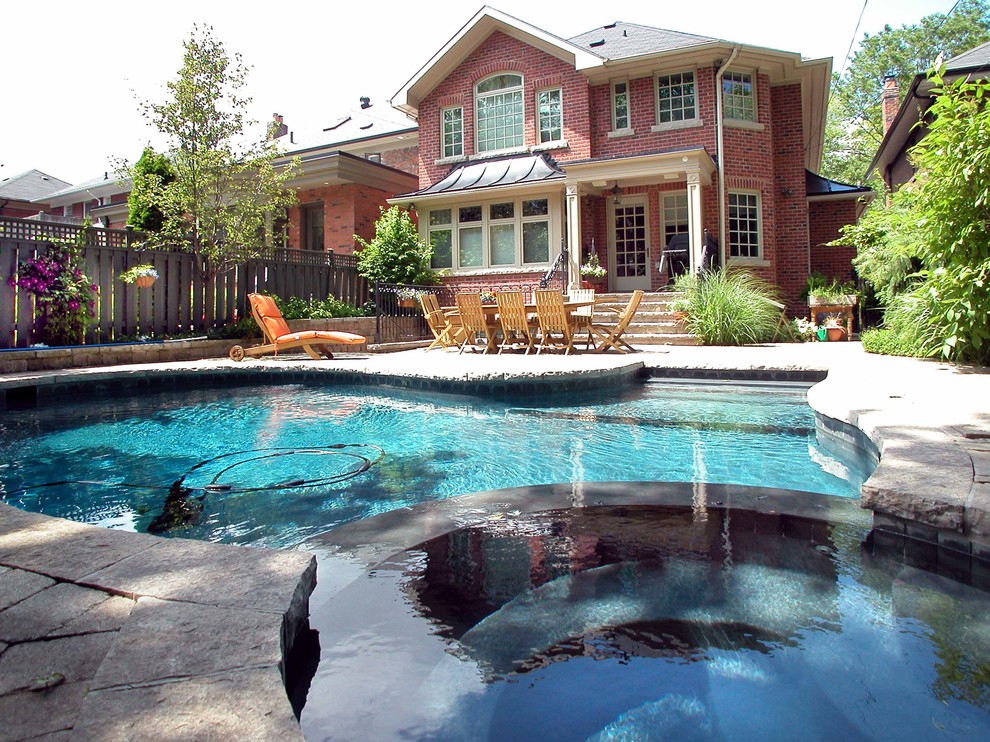 Bild på en mellanstor vintage anpassad pool på baksidan av huset, med spabad och marksten i betong