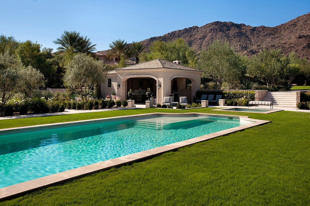 Ejemplo de casa de la piscina y piscina alargada clásica grande rectangular en patio trasero con suelo de hormigón estampado