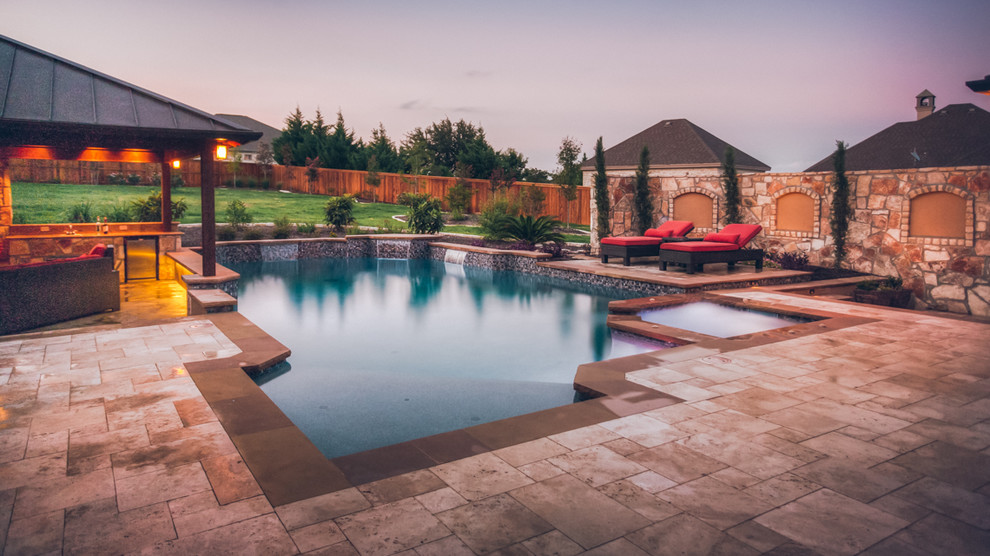Photo of a large traditional back custom shaped lengths swimming pool in Austin with natural stone paving and a pool house.