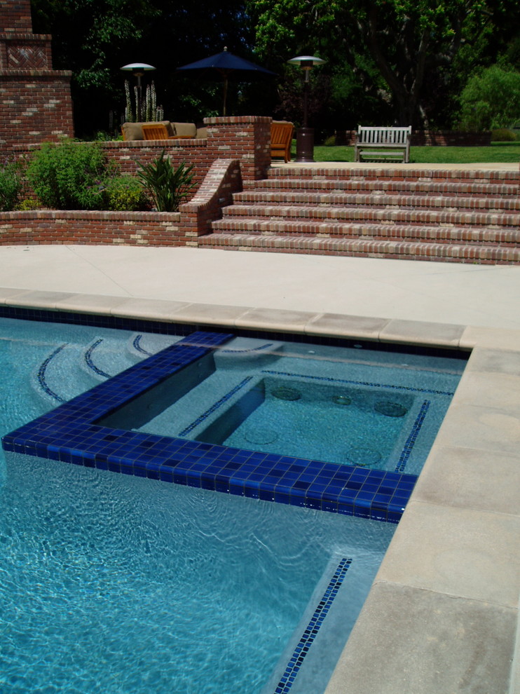 Стильный дизайн: большой прямоугольный бассейн на заднем дворе в классическом стиле с джакузи и покрытием из бетонных плит - последний тренд