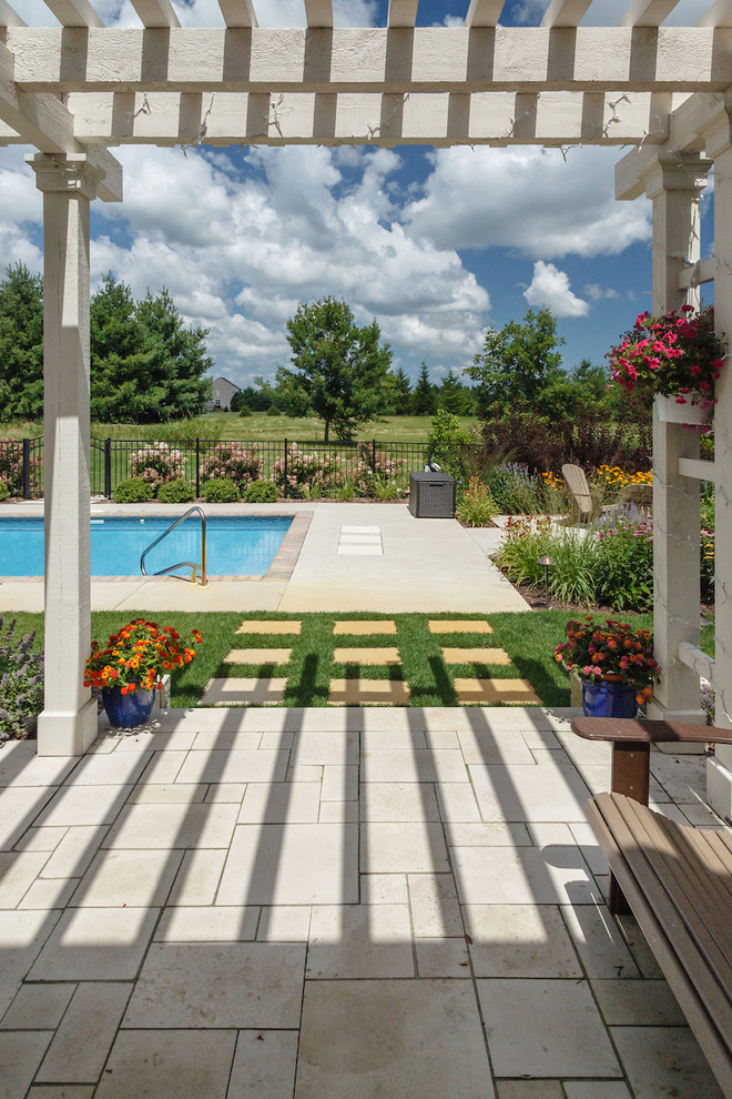 Ispirazione per una piscina classica rettangolare di medie dimensioni e dietro casa con pavimentazioni in pietra naturale