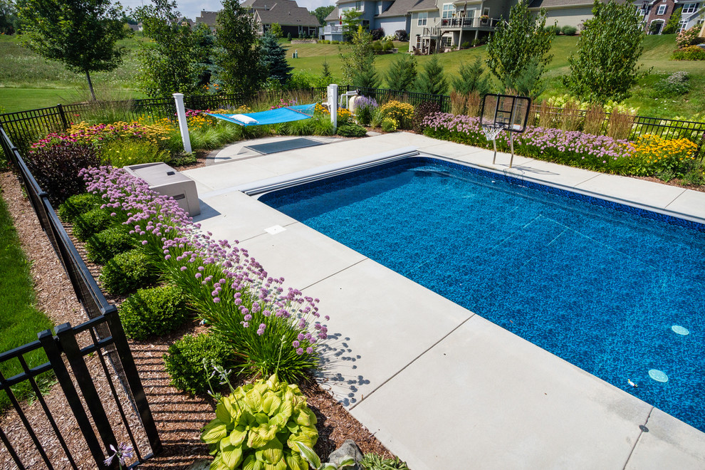 Idee per una piscina chic rettangolare di medie dimensioni e dietro casa con lastre di cemento e una dépendance a bordo piscina