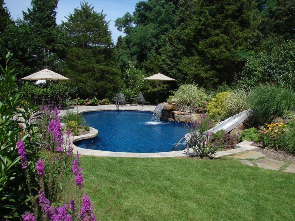 Foto di una piscina naturale tradizionale personalizzata di medie dimensioni e dietro casa con una vasca idromassaggio e pavimentazioni in pietra naturale