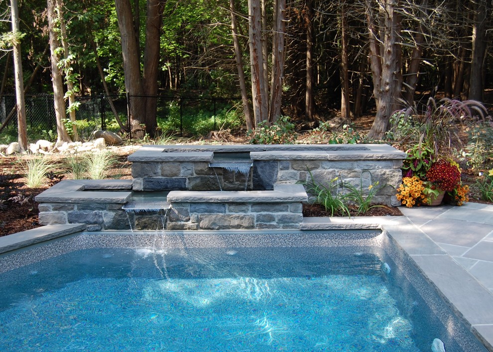 Design ideas for a traditional swimming pool in Toronto with a water feature.