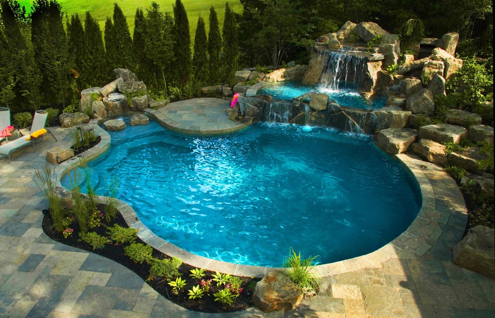 На фото: большой бассейн произвольной формы на заднем дворе в классическом стиле