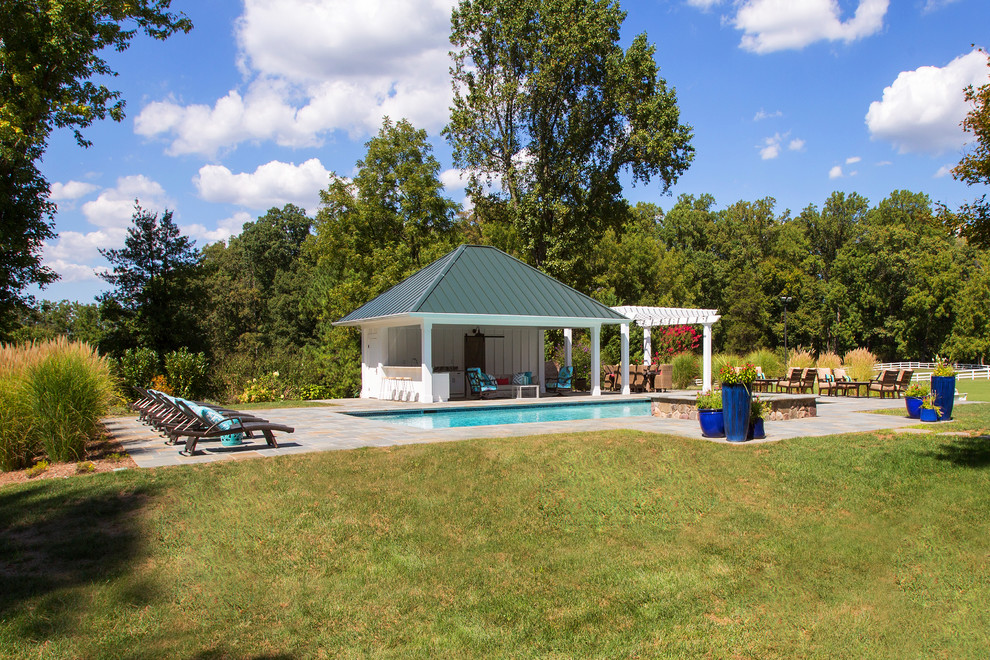 Modelo de piscinas y jacuzzis alargados clásicos grandes rectangulares en patio trasero con adoquines de piedra natural