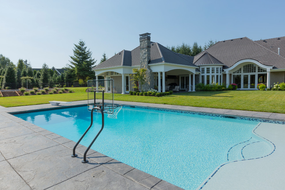 Esempio di una piscina monocorsia classica rettangolare di medie dimensioni e dietro casa con lastre di cemento