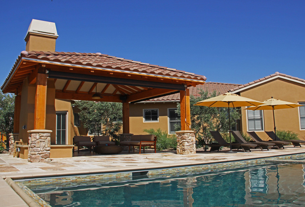 Пример оригинального дизайна: большой спортивный, прямоугольный бассейн на заднем дворе в средиземноморском стиле с покрытием из каменной брусчатки