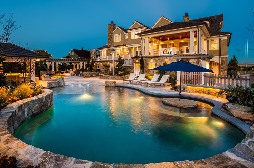 Inspiration for a large rustic back custom shaped natural swimming pool in New York with natural stone paving.