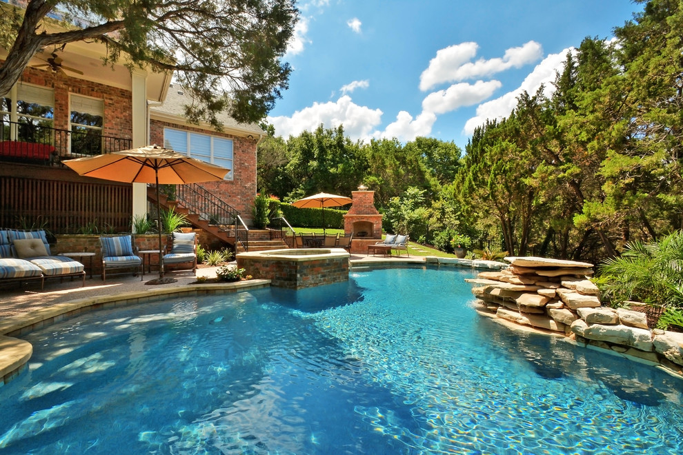 Immagine di una piscina tradizionale personalizzata dietro casa con pavimentazioni in pietra naturale
