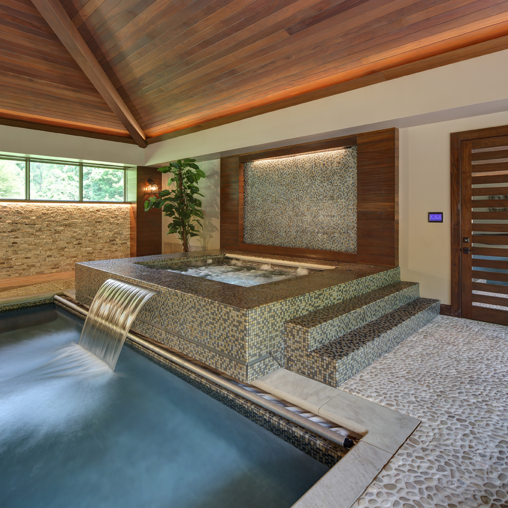 Пример оригинального дизайна: прямоугольный бассейн в доме в современном стиле с фонтаном и настилом