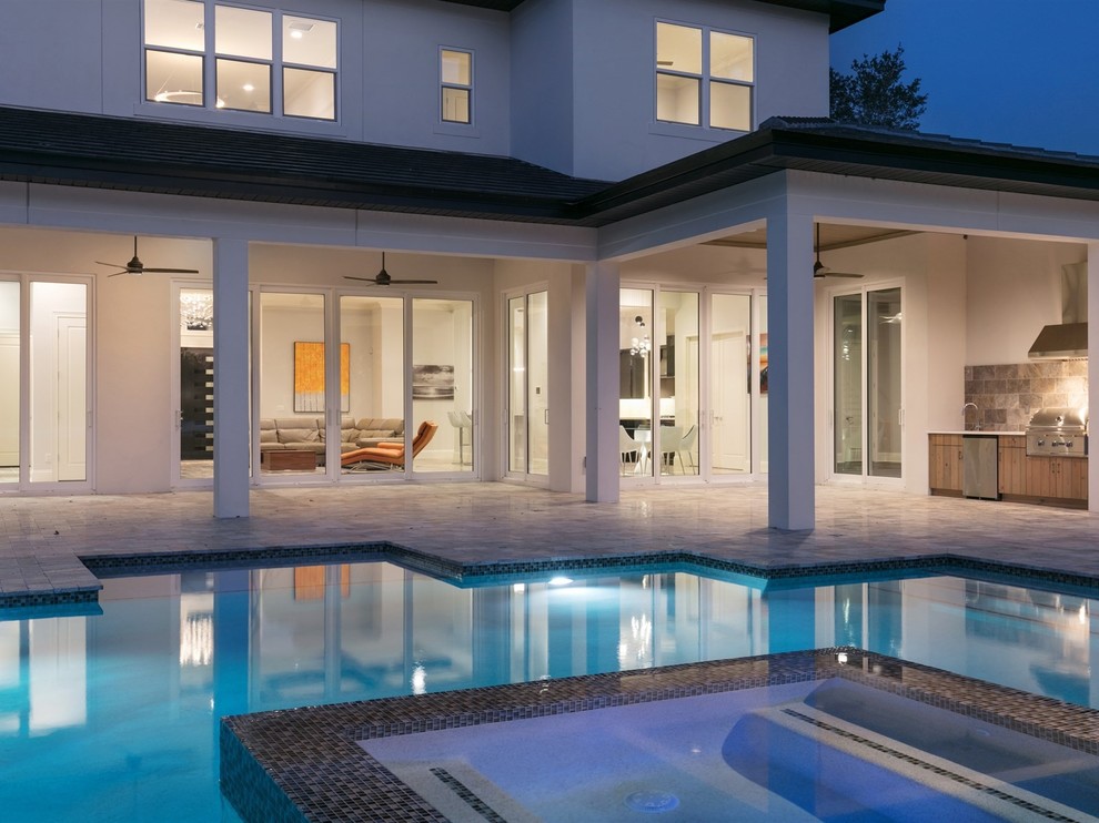 Hot tub - large modern backyard tile and custom-shaped hot tub idea in Orlando