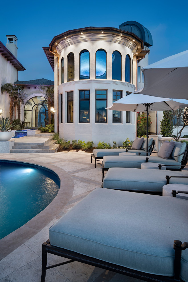 Foto de piscinas y jacuzzis clásicos renovados extra grandes tipo riñón en patio trasero con adoquines de piedra natural