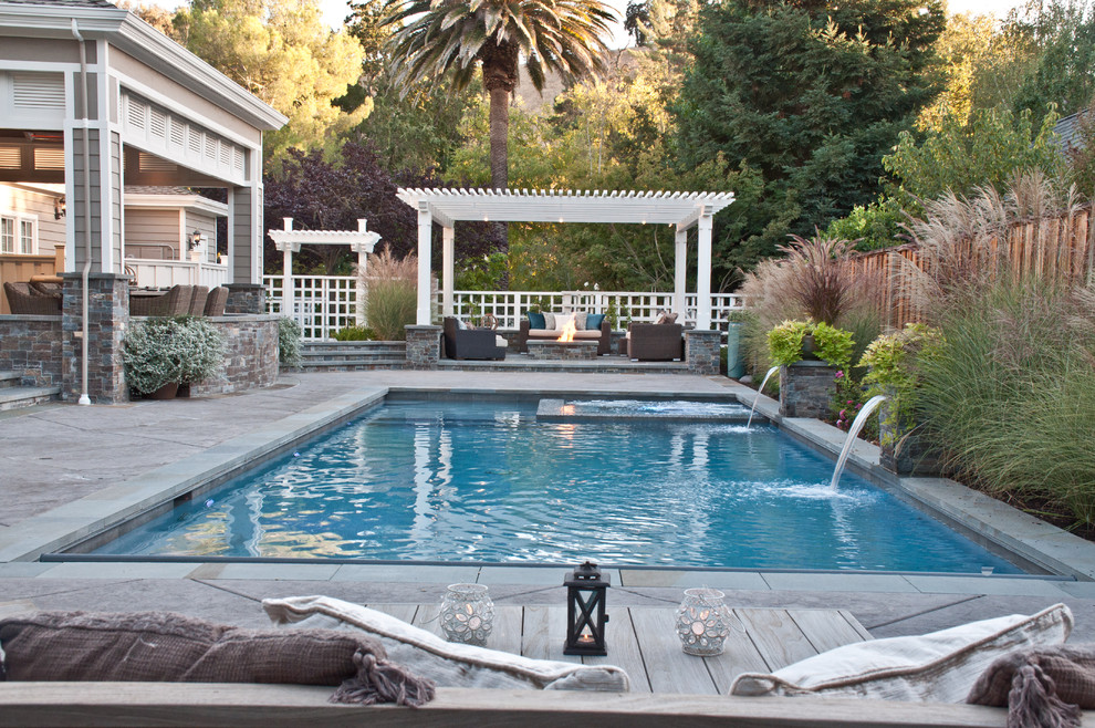 Modelo de piscina con fuente alargada campestre grande rectangular en patio trasero