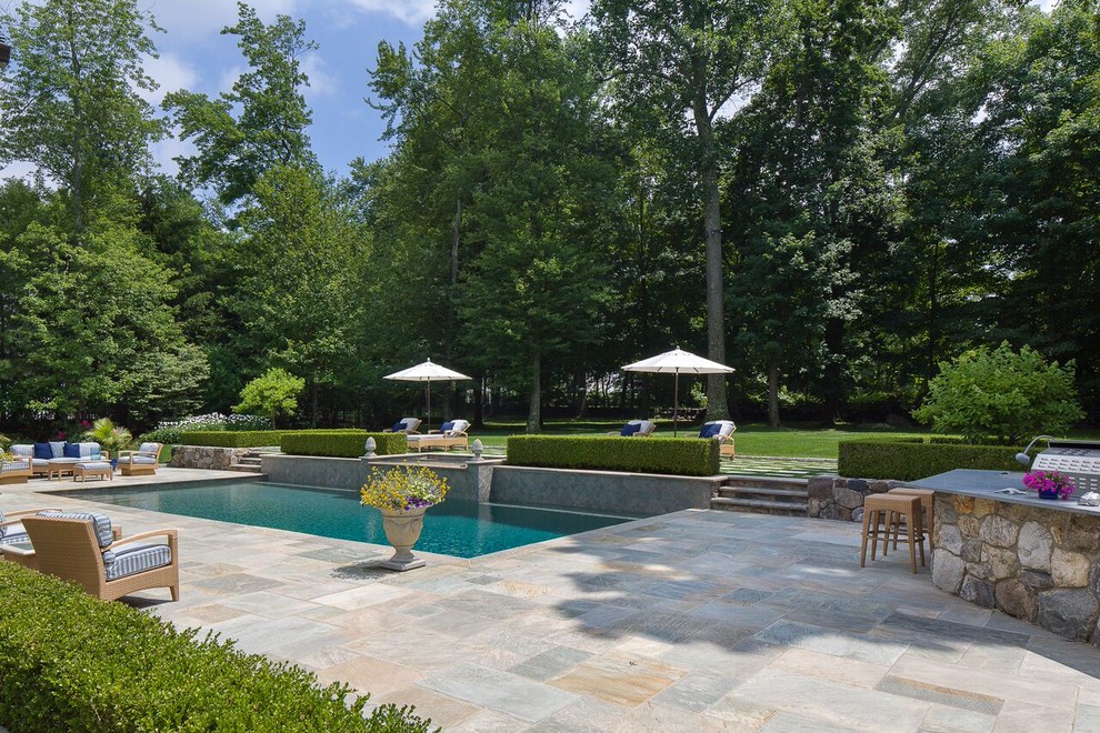 Diseño de piscinas y jacuzzis alargados clásicos renovados de tamaño medio rectangulares en patio trasero con adoquines de piedra natural