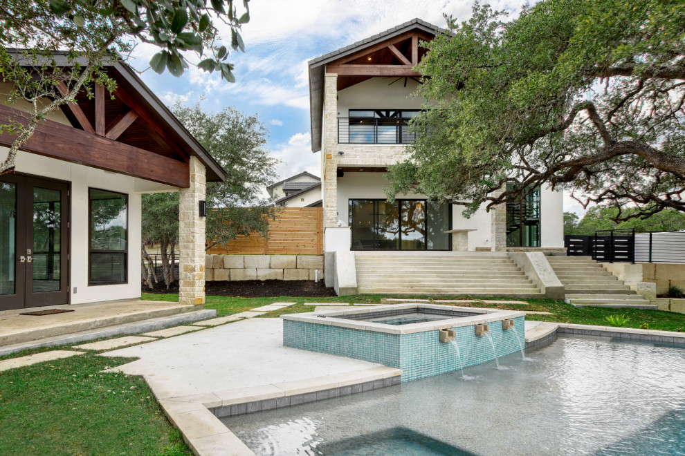 Foto di un'ampia piscina naturale classica personalizzata dietro casa con una vasca idromassaggio e pavimentazioni in cemento