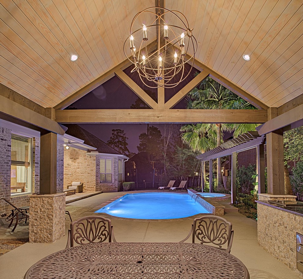 This is an example of a medium sized traditional back custom shaped swimming pool in Houston with natural stone paving.