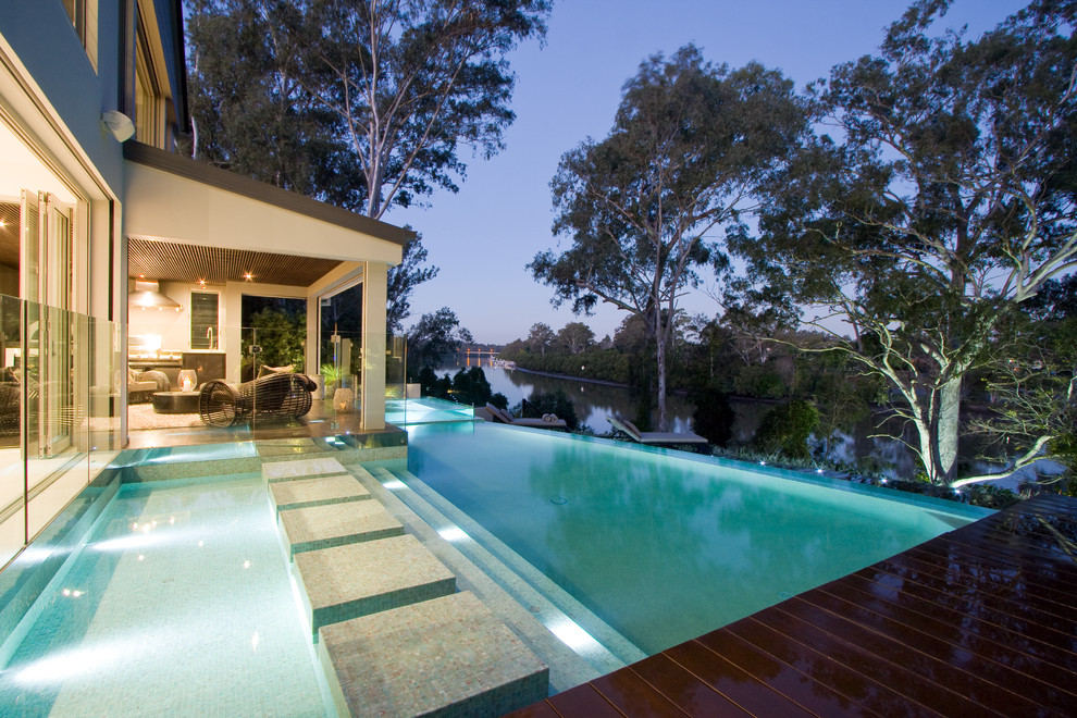 Exemple d'une piscine chic avec une terrasse en bois.