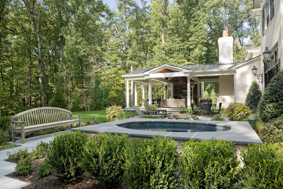 Photo of a traditional back round hot tub in Baltimore with natural stone paving.