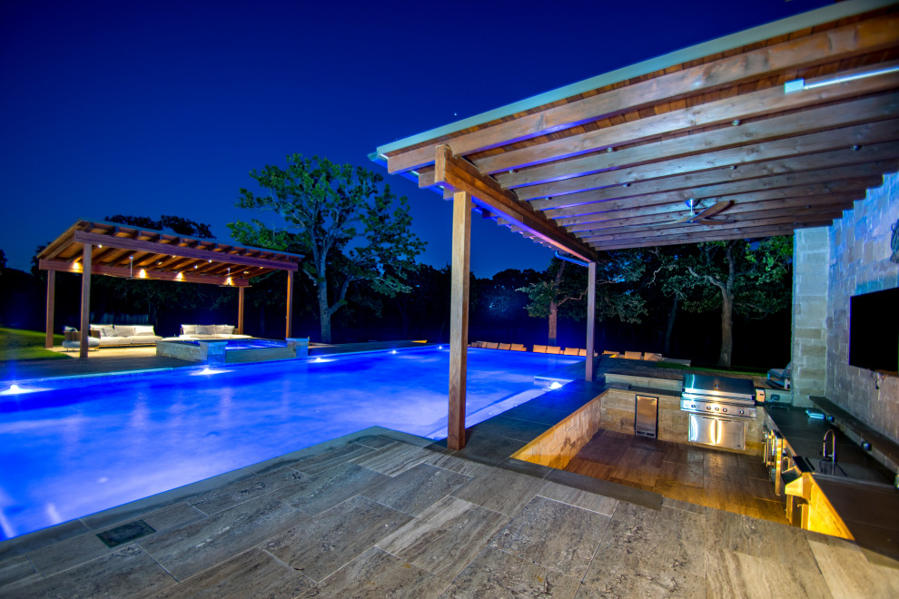 Geräumiger Klassischer Infinity-Pool hinter dem Haus in rechteckiger Form mit Wasserspiel und Natursteinplatten in Dallas
