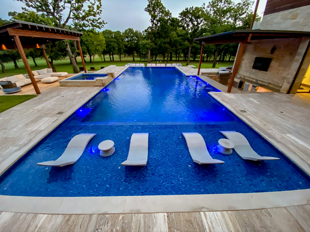 Inspiration pour une très grande piscine à débordement et arrière traditionnelle rectangle avec un point d'eau et des pavés en pierre naturelle.