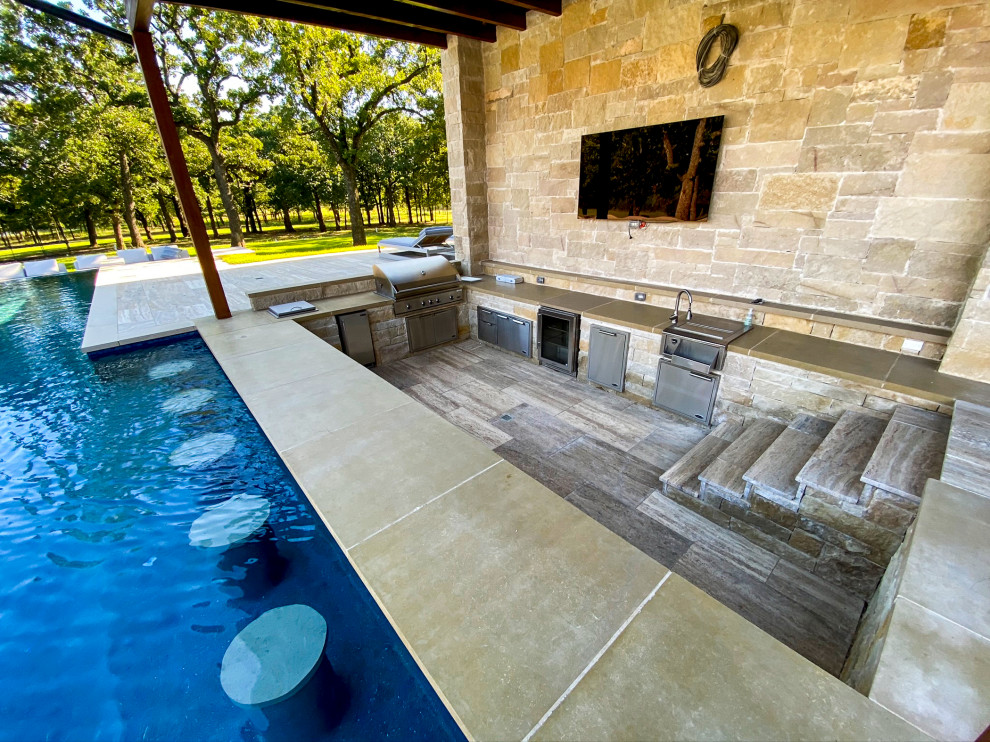 Esempio di un'ampia piscina a sfioro infinito classica rettangolare dietro casa con fontane e pavimentazioni in pietra naturale