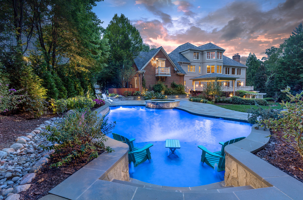 This is an example of a classic back custom shaped lengths hot tub in DC Metro with natural stone paving.