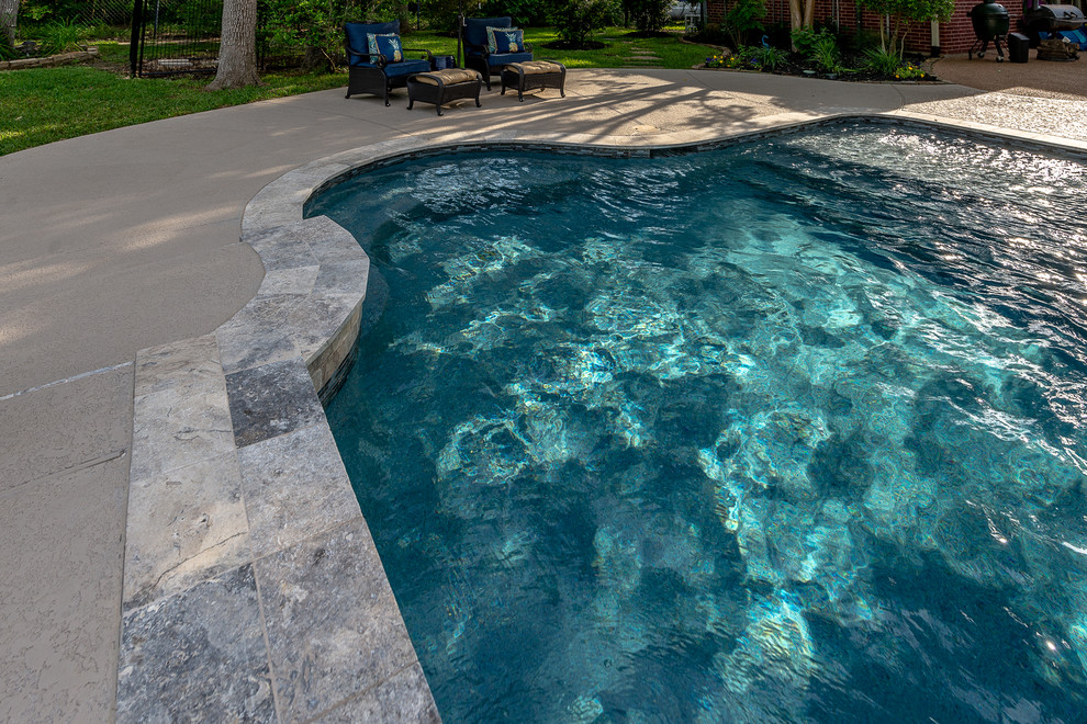 Idee per una piscina naturale tropicale personalizzata di medie dimensioni e dietro casa con una vasca idromassaggio e pedane