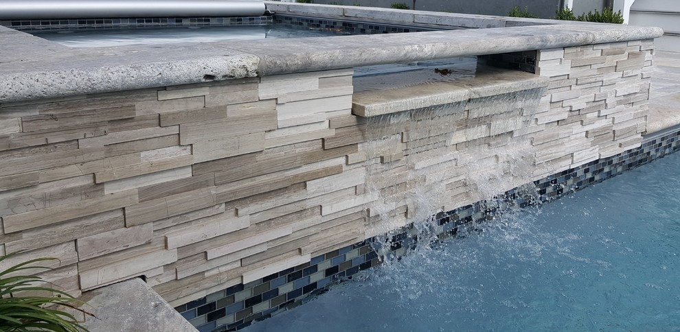Idee per una piscina fuori terra tradizionale dietro casa con fontane e pavimentazioni in pietra naturale