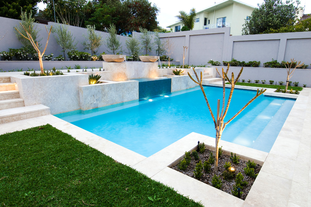Mittelgroßer Moderner Schwimmteich hinter dem Haus in rechteckiger Form mit Wasserspiel und Natursteinplatten in Perth
