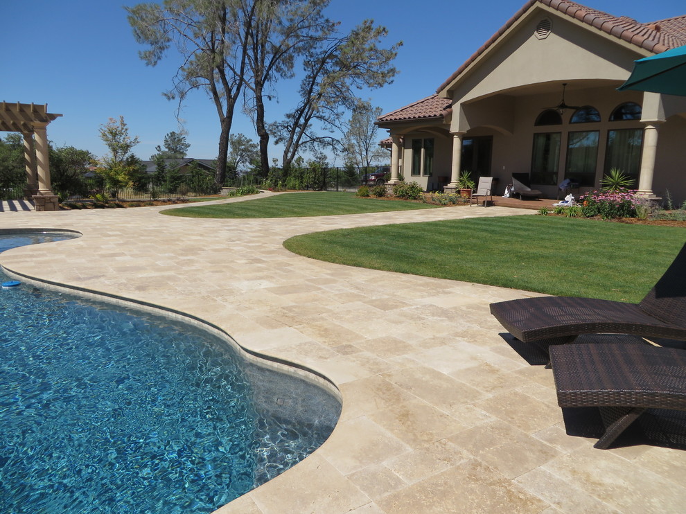 Photo of a mediterranean back custom shaped swimming pool in Sacramento with natural stone paving.