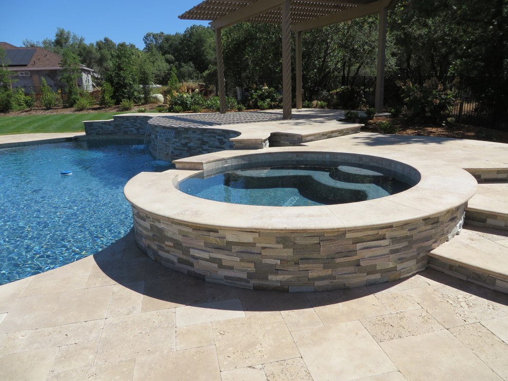 Large mediterranean back custom shaped swimming pool in Sacramento with natural stone paving.