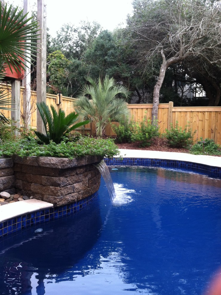 Großer Moderner Pool hinter dem Haus in individueller Form mit Wasserspiel und Natursteinplatten in Sonstige