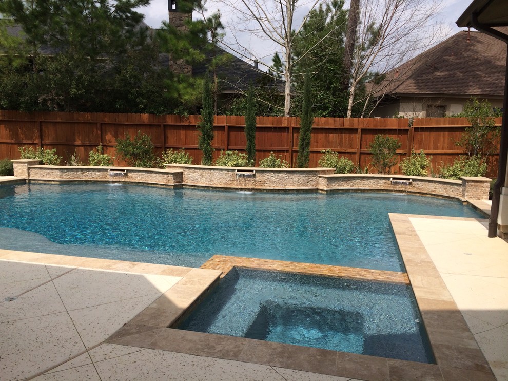 Modelo de piscinas y jacuzzis clásicos de tamaño medio a medida en patio trasero con losas de hormigón