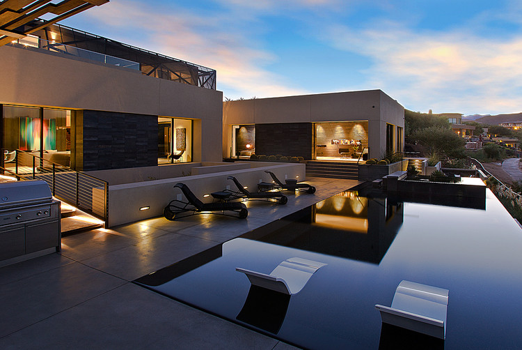 Foto de piscina infinita contemporánea grande rectangular en patio trasero con losas de hormigón