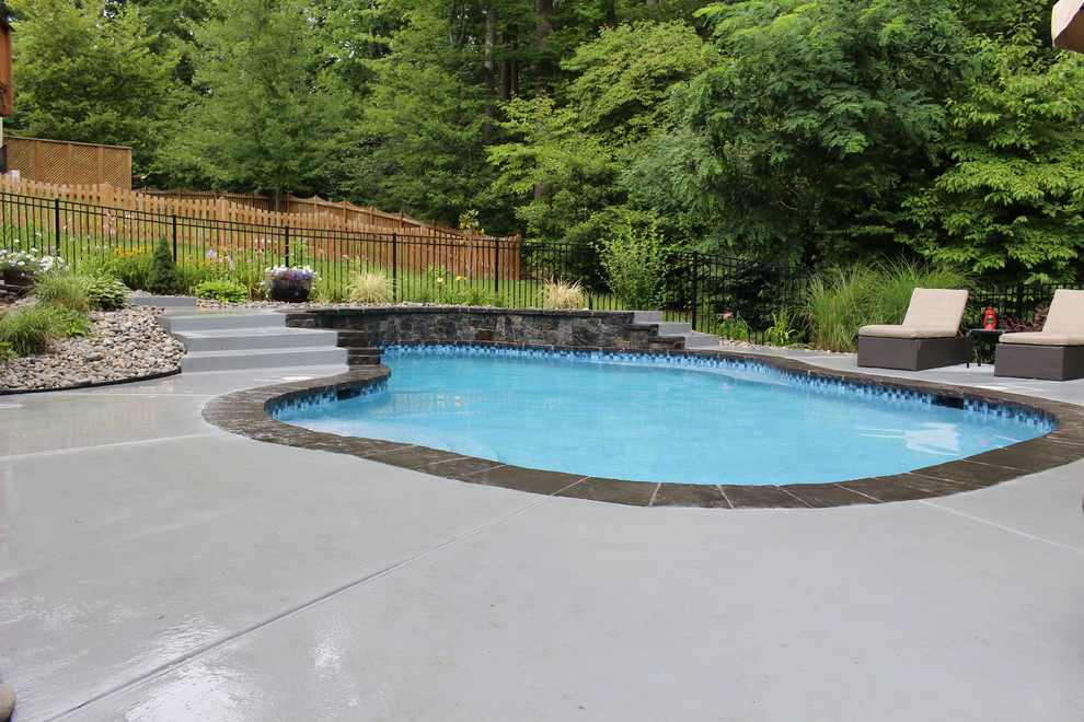 Example of a small mountain style backyard custom-shaped natural pool design in DC Metro with decking