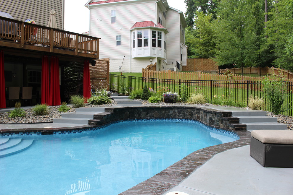 Imagen de piscina natural rural pequeña a medida en patio trasero con entablado
