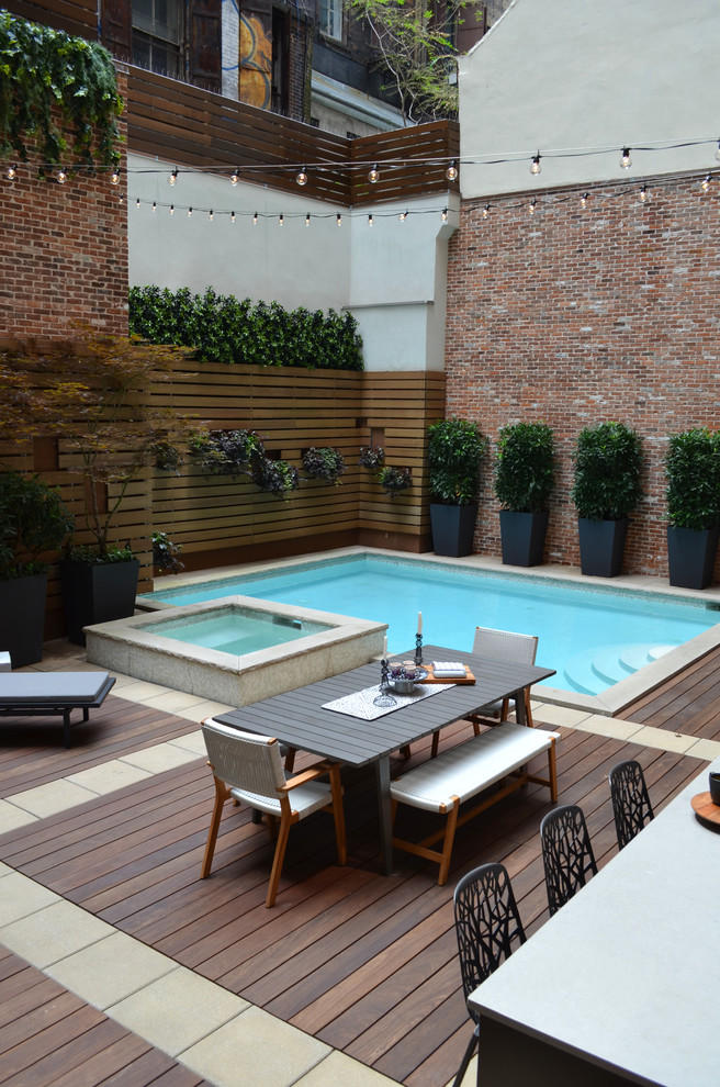 На фото: маленький прямоугольный бассейн на заднем дворе в современном стиле с джакузи и настилом для на участке и в саду