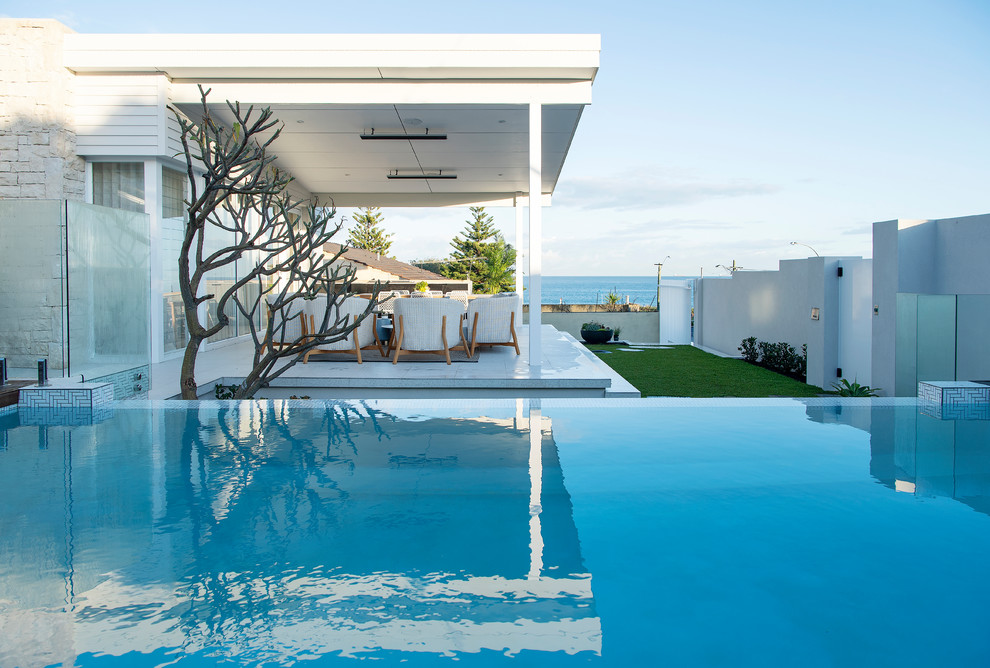 Foto di una piscina a sfioro infinito stile marinaro rettangolare di medie dimensioni e dietro casa