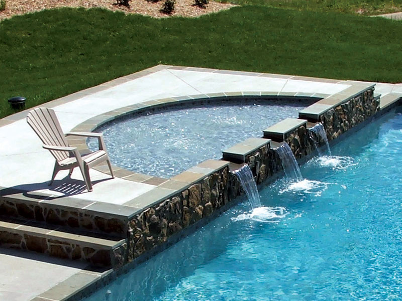 Diseño de piscinas y jacuzzis alargados exóticos grandes a medida en patio trasero con adoquines de hormigón