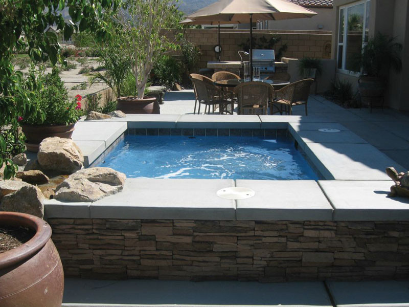 На фото: большой прямоугольный бассейн на заднем дворе в стиле неоклассика (современная классика) с джакузи и мощением тротуарной плиткой с