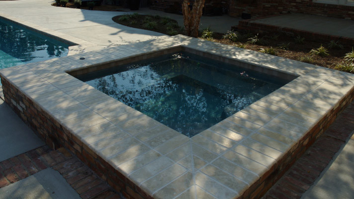 Imagen de piscinas y jacuzzis tradicionales renovados grandes rectangulares en patio trasero con adoquines de hormigón