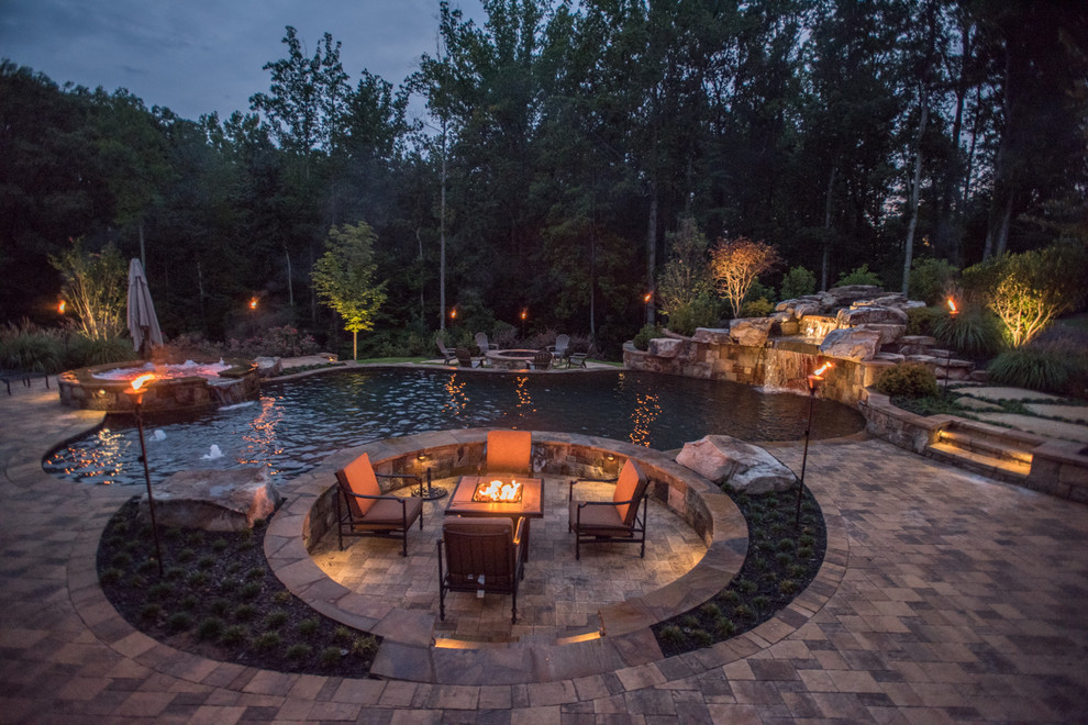 Example of a huge island style backyard stone and custom-shaped natural hot tub design in Atlanta